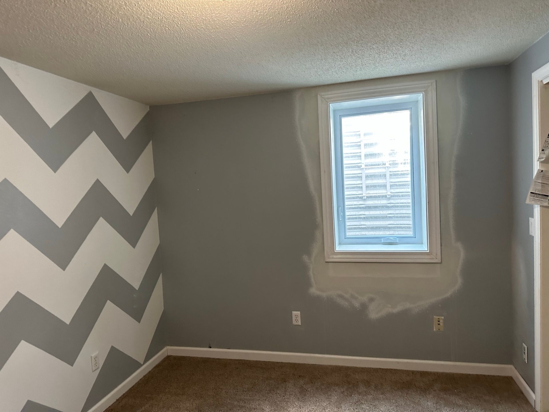 Finished basement bedroom with carpet and a casement egress window with white steel well, Bethalto, Illinois, installed by GHR Egress Windows.